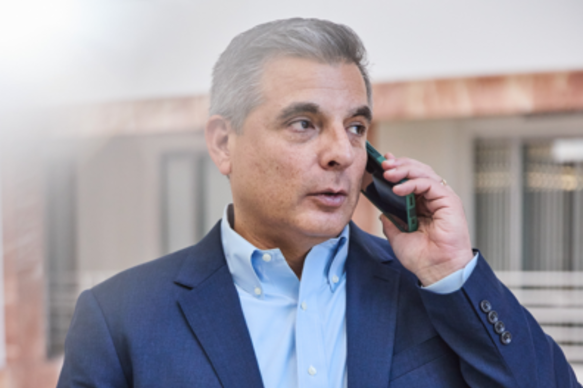 Business owner in a navy suit taking an important phone call, focused and engaged in a professional setting.