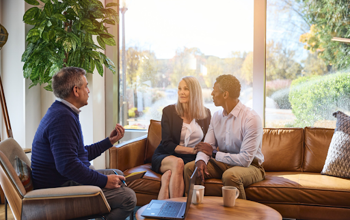 Financial advisor meeting with a couple in a bright office, discussing estate and wealth transfer planning, including GRAT strategies for preserving assets and reducing potential estate tax exposure.